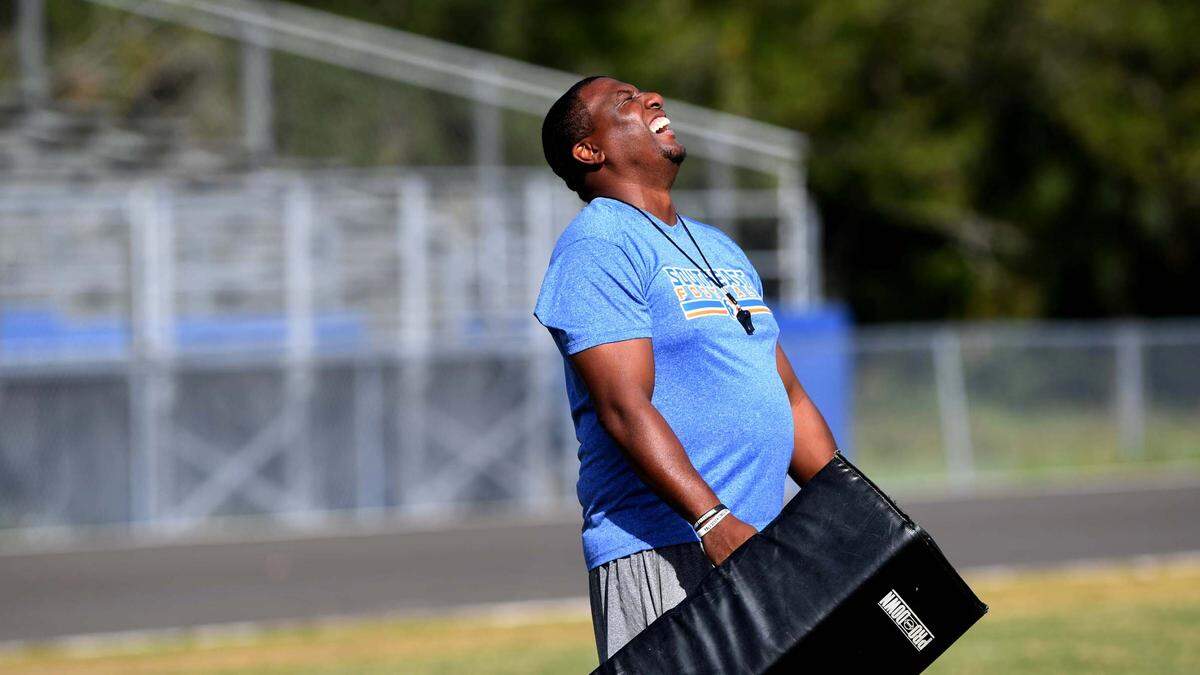 Head coach Brett Timmons laughs during Southeast High School football practice, October 24, 2022.