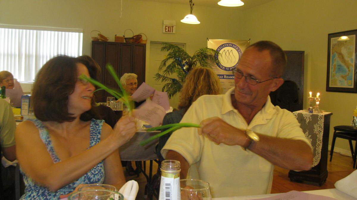 Meg and Art Durshimer at last year's Passover Seder at Congregation Ner Tamid in Bradenton are "whipping" each other with scallions. It is a Sefardi Jewish custom (Jews from Spain, Portugal and the Middle East,) as opposed to Ashkenizi (Jews from Eastern Europe) to commemorate the whippings slaves received from Egyptian taskmasters.PHOTO PROVIDED