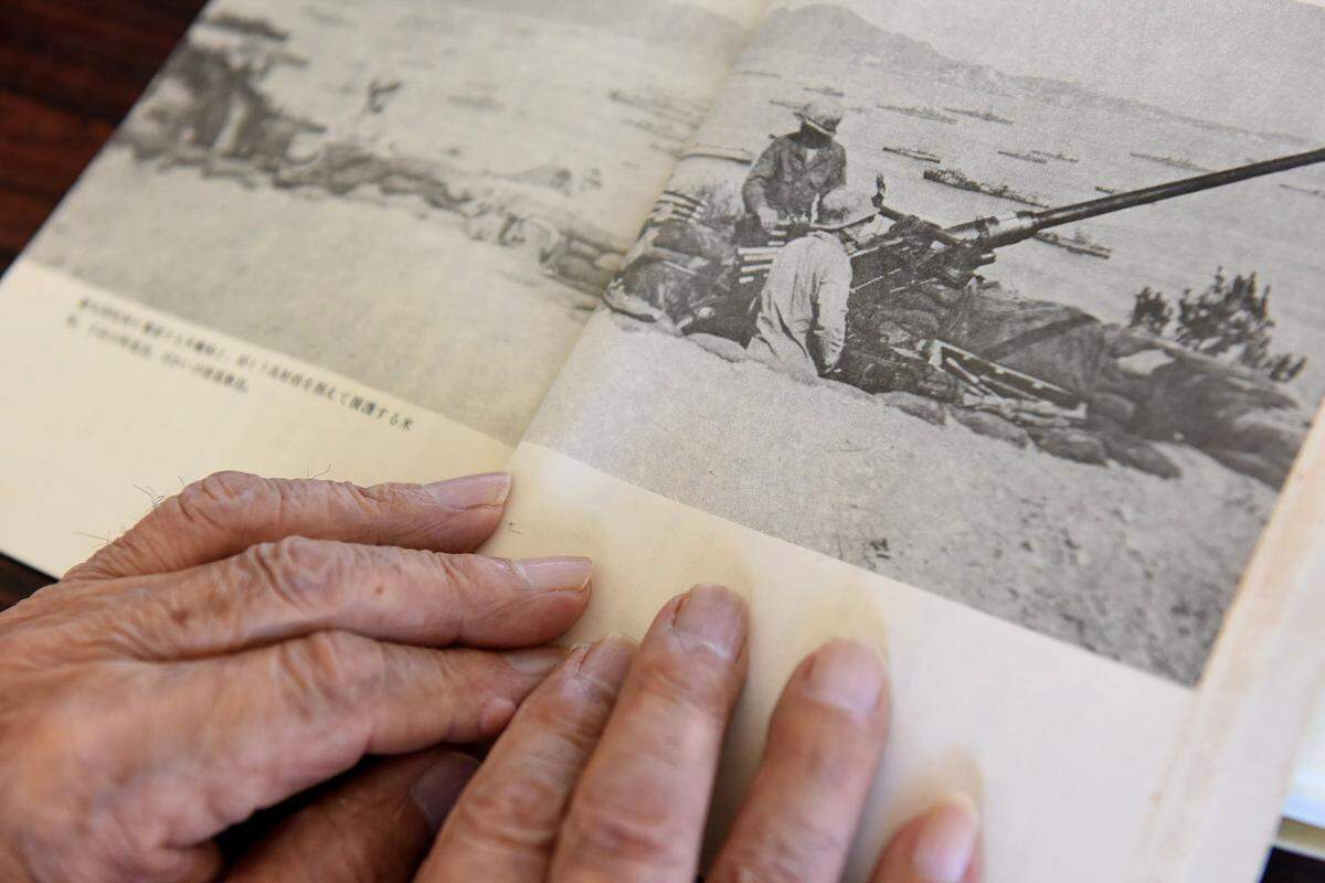 Takeichi Kakinohana, 85, shows a photograph of the U.S. military landing in the waters around his home, the tiny island of Aka in the Pacific. In late March, 1945, the island endured attacks by fighter planes and naval artillery as the civilians and Japanese soldiers hid on the highest mountain. (Tiffany Tompkins-Condie/McClatchy DC/TNS)