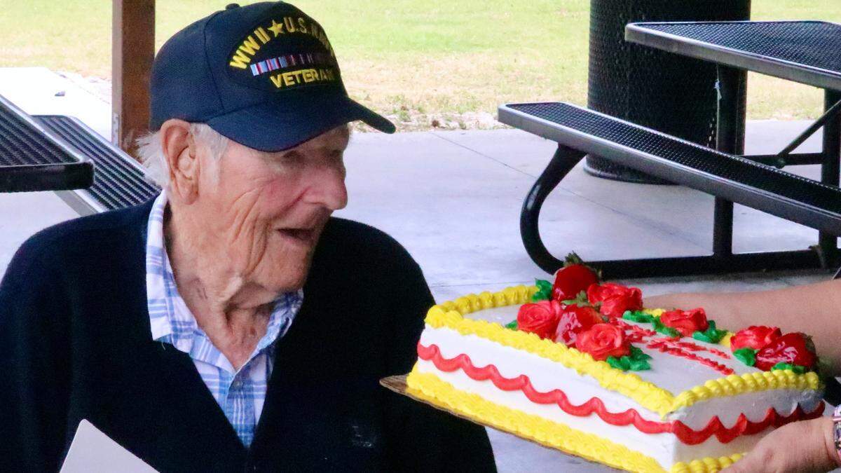 Warren Pizzello, a Bradenton resident and World War II Navy veteran, takes a look at the cake baked for his 100th birthday on March 15, 2022.