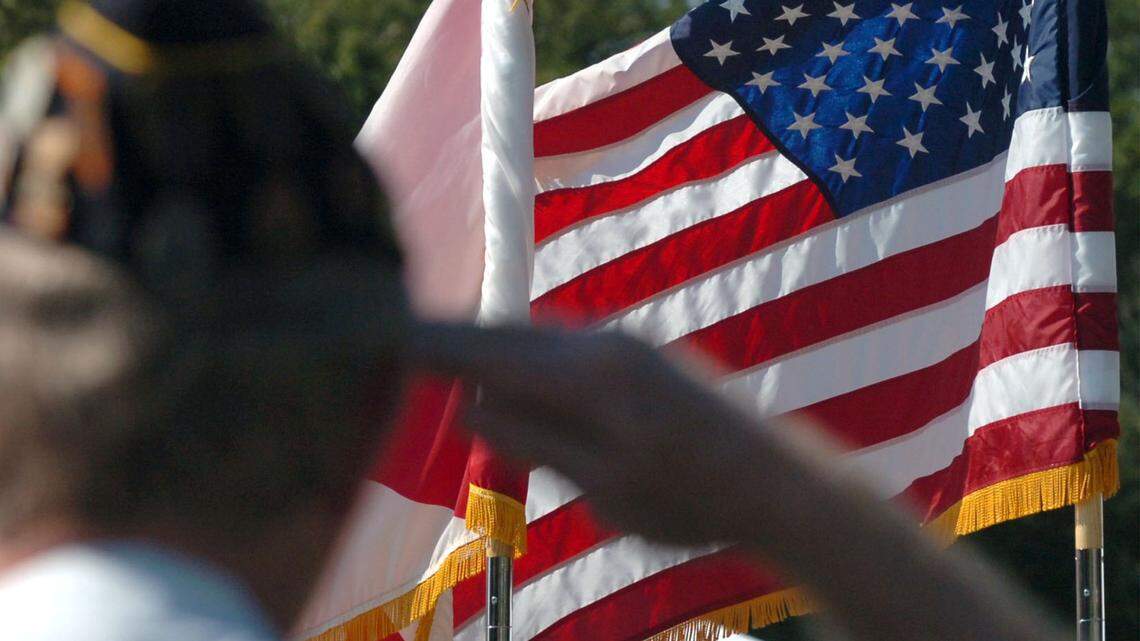 A veteran salutes as the American flag passes before him during a Veterans Day parade in Florida in this 2018 file photo.