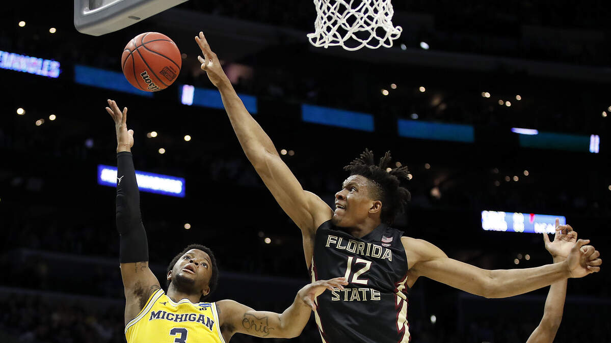 Florida State center Ike Obiagu (12) blocks a shot by Michigan guard Zavier Simpson (3) during the first half of an NCAA men's college basketball tournament regional final Saturday, March 24, 2018, in Los Angeles.