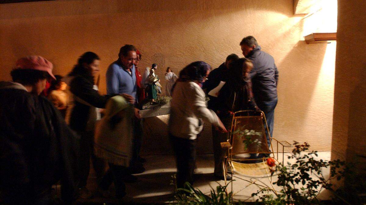 12/22/2005--Participants sing and pray as they carry candles and statues of Joseph and Mary from house to house during a La Posada celebration in Palmetto.