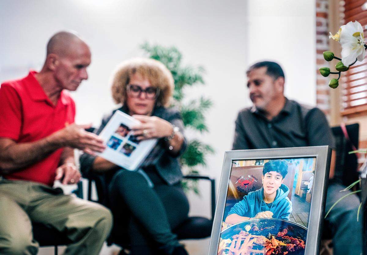 The parents of Derbin Huertas Jr., Ana and Derbin Sr., share family photos with cornea recipient Art Durshimer at Lions World Vision Institute in Ybor City.