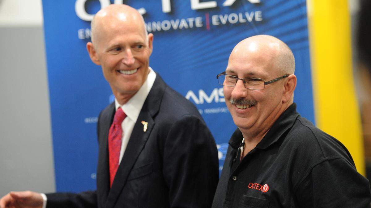 Florida Gov. Rick Scott compares hair styles with Octex employee Greg Luzier during a visit at Octex on Wednesday in Sarasota, highlighting job creation in Florida. 
 GRANT JEFFERIES/Bradenton Herald