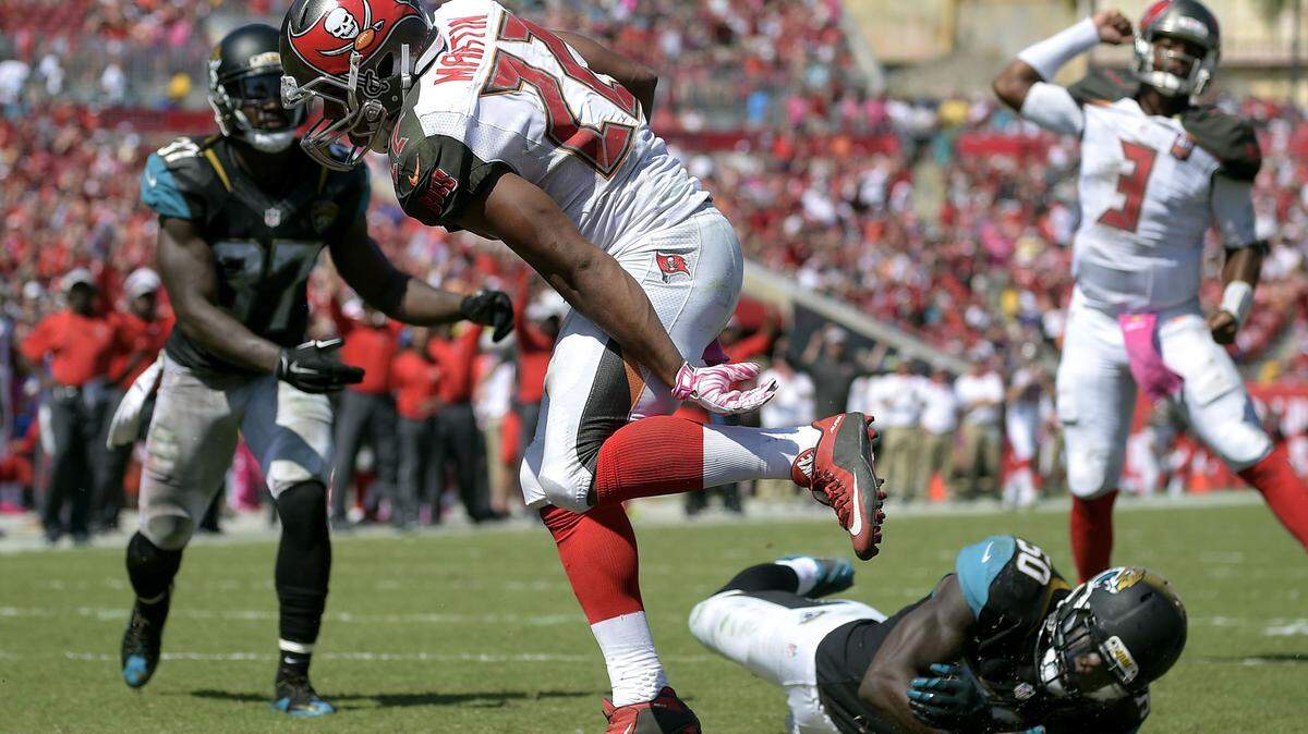 Tampa Bay Buccaneers running back Doug Martin (22) runs into the end zone after getting past Jacksonville Jaguars strong safety Johnathan Cyprien (37) and outside linebacker Telvin Smith (50) on a 1-yard touchdown run during the second quarter of an NFL football game Sunday, Oct. 11, 2015, in Tampa, Fla. (AP Photo/Phelan M. Ebenhack)