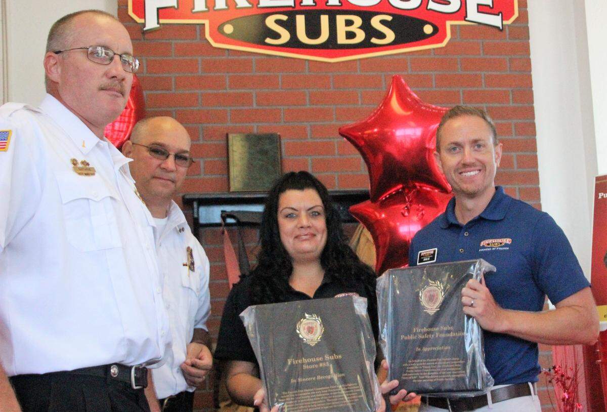 Firefighters, Firehouse Subs staff, and representatives of Firehouse Subs Public Safety Foundation gathered as the Parrish Fire District received more than $30,000 of life-saving equipment on Thursday. Shown above, from left, are Capt. Jason Guthrie, Fire Chief Stacey Bailey, Firehouse Subs restaurant general manager Natasha Denno, and  Firehouse Subs Fire Marshal John Cz.