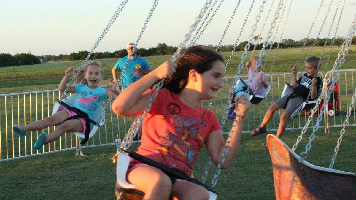 Children go for a swing during Lakewood Ranch's 20th anniversary celebration. 
 JAMES A. JONES JR./Bradenton Herald