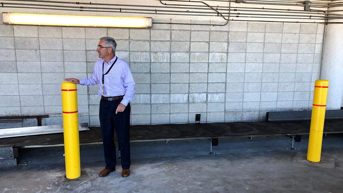 Rick Piccolo, president an CEO of Sarasota Bradenton International Airport, stands next to the outside wall of the terminal taken out by a truck traveling at high speed a week ago. The crash also heavily damaged a baggage handling belt behind him. One of yellow bollards may have helped deflect the trajectory of the truck as it smashed into the building.
