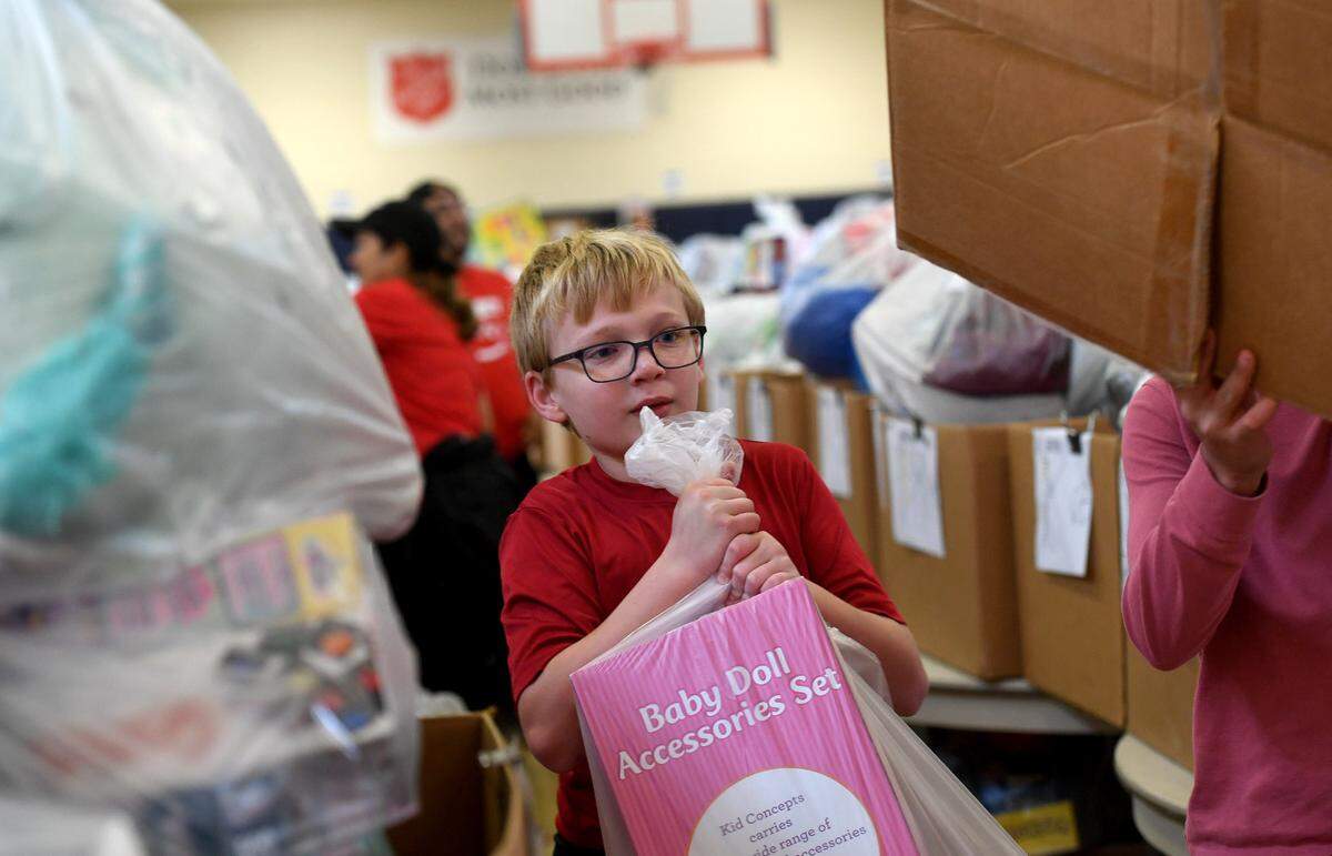 Liam Geske, 12, works with dozens of volunteers gathering toys that were collected for 786 families on the Salvation Army’s Angel Tree Distribution Day. Families registered in September to receive presents for their children along with a turkey or ham. The distribution was drive-through style, with volunteers working together to make the event run smoothly.