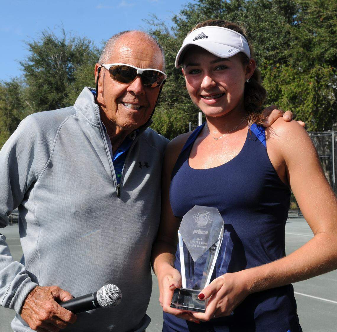 Kylie McKenzie is awarded the championship trophy by Nick Bollettieri the Eddie Herr Junior Championship Saturday Dec 6th.