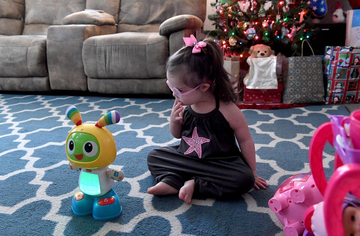 Maddie Gordon, 2, plays with her favorite toys in her living room, pink bow holding a curled ponytail that bounces as she moves. Maddie’s pediatric therapy program at Blake Medical will soon be moving to Manatee Memorial Hospital.