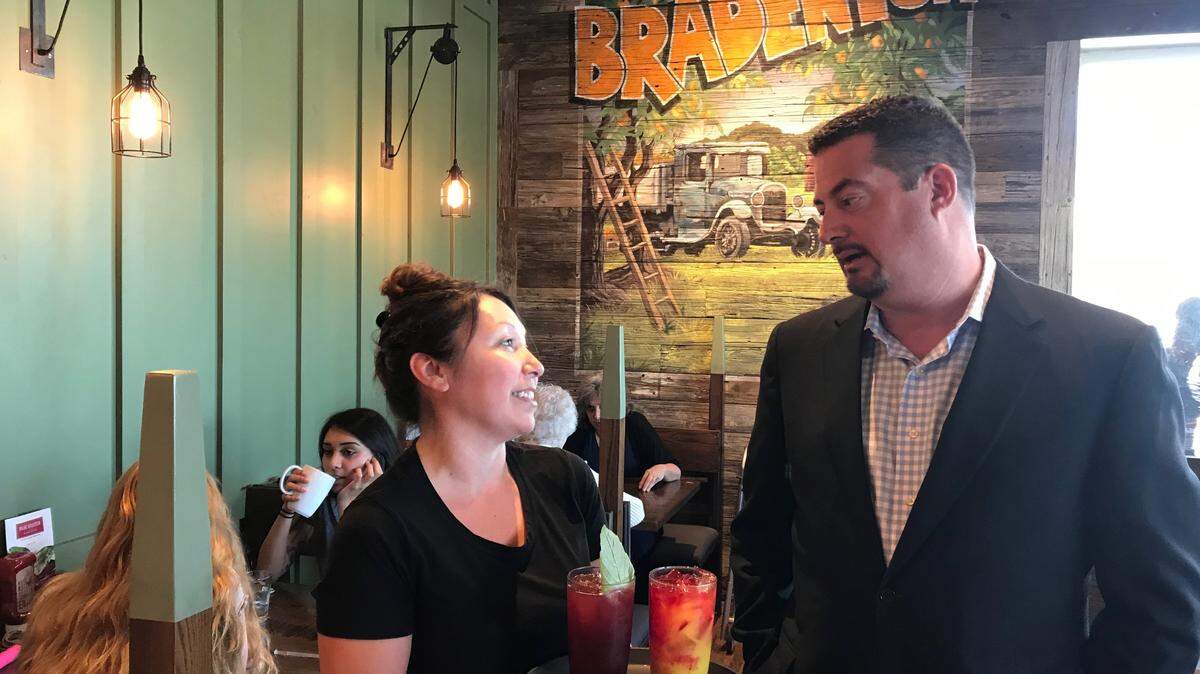 First Watch CEO Chris Tomasso visits with wait staff member Anya Christianson at the &nbsp;4324 53rd Ave. E. restaurant location.