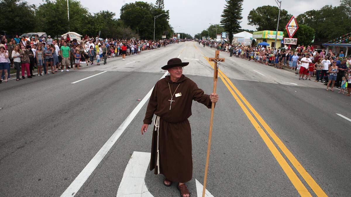 Joe Miller as the DeSoto Padre holds his cross on Manatee Avenue as crowds cheer and yell for beads during the annual DeSoto Grand Parade in this file photo.