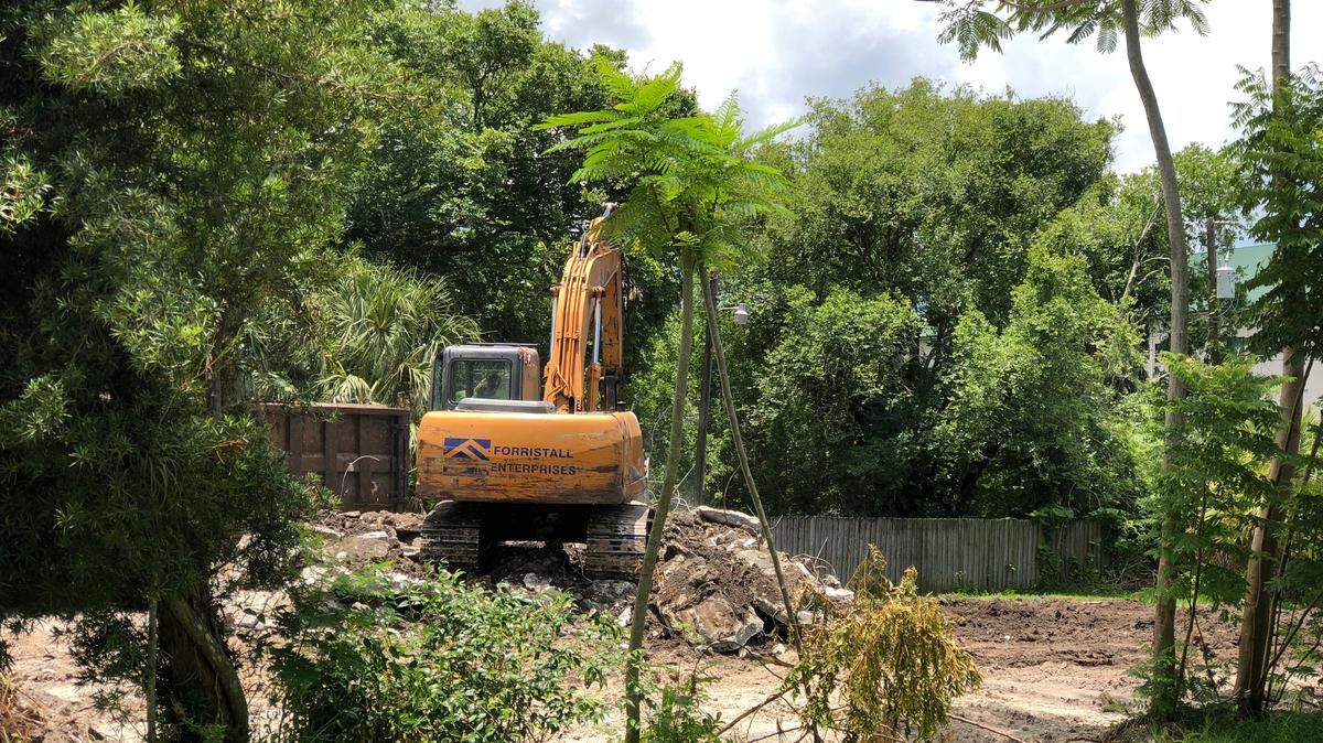 A bulldozer tears down a home in the 700 block of 15th Ave. Drive E. Manatee School for the Arts has bought 11 homes on this street over the past three years.