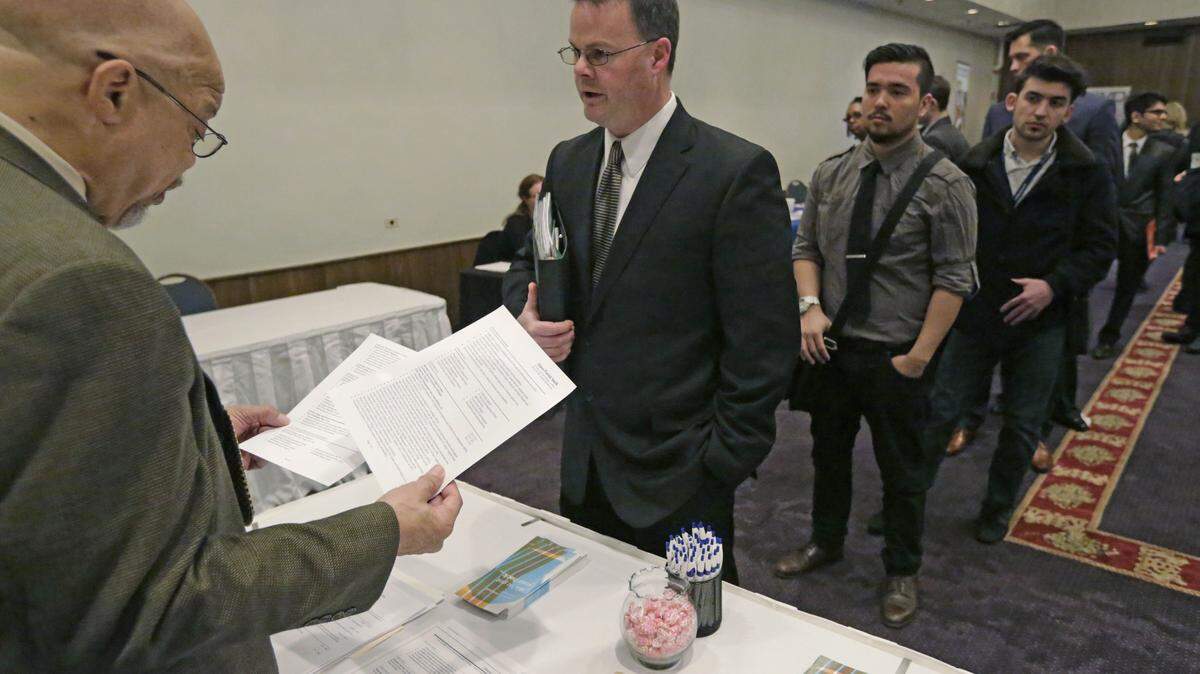 FILE - In this April 22, 2015 file photo, Ralph Logan, general manager of Microtrain, left, speaks with James Smith who is seeking employment during a National Career Fairs job fair in Chicago. U.S. employers notched another solid month of hiring in March by adding 215,000 jobs, driven by large gains in the construction, retail and health care industries. Despite the jump, the Labor Department said Friday, April 1, 2016 that the unemployment rate ticked up to 5 percent from 4.9 percent. (AP Photo/M. Spencer Green, File)