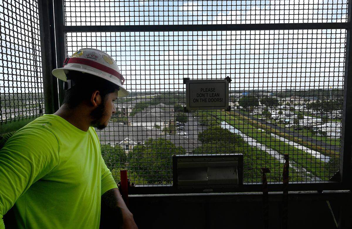 A construction worker looks below from the elevator cage in the new Marriott Palmetto Resort at the Bradenton Area Convention Center.