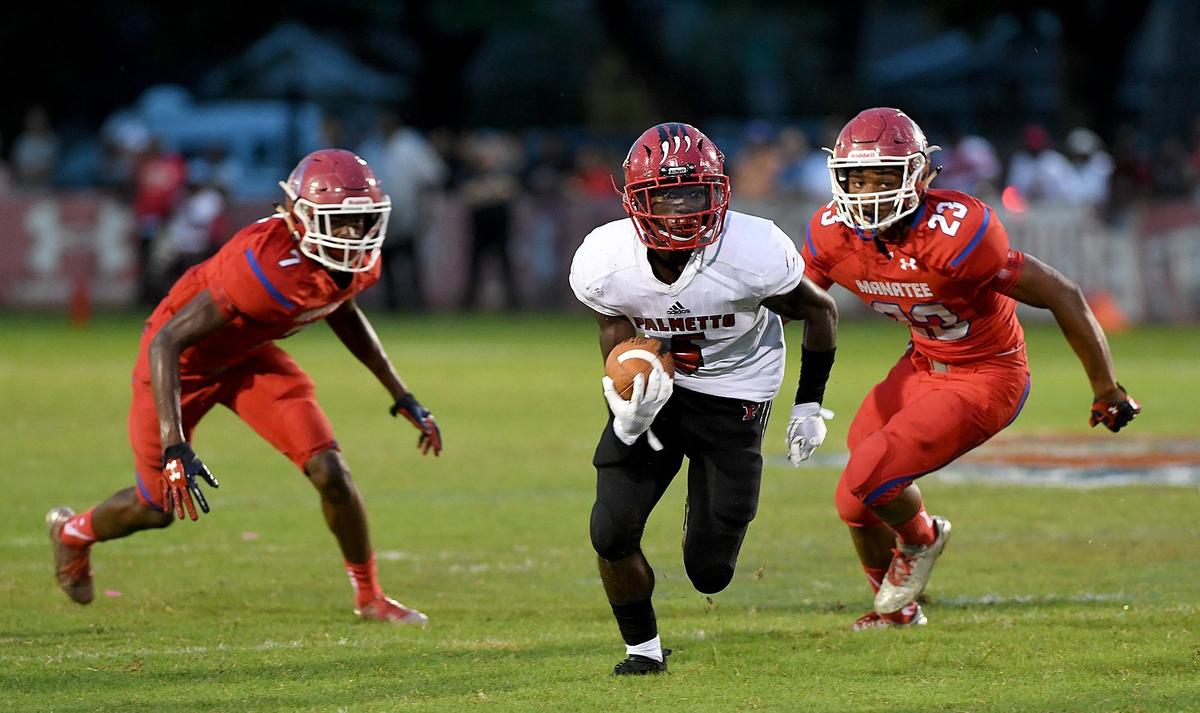 Palmetto’s Eddravian Butler splits the defense and looks for extra yardage during Friday’s game.