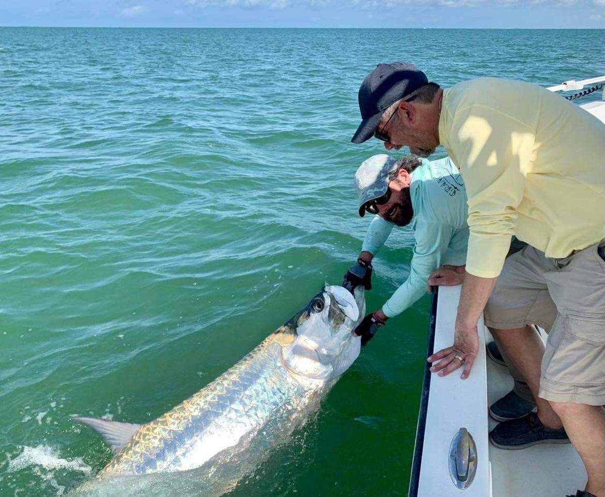 Captain Jason Wightman holds a tarpon. He runs a charter fishing business called Grande Tarpon Charters out of Palmetto.