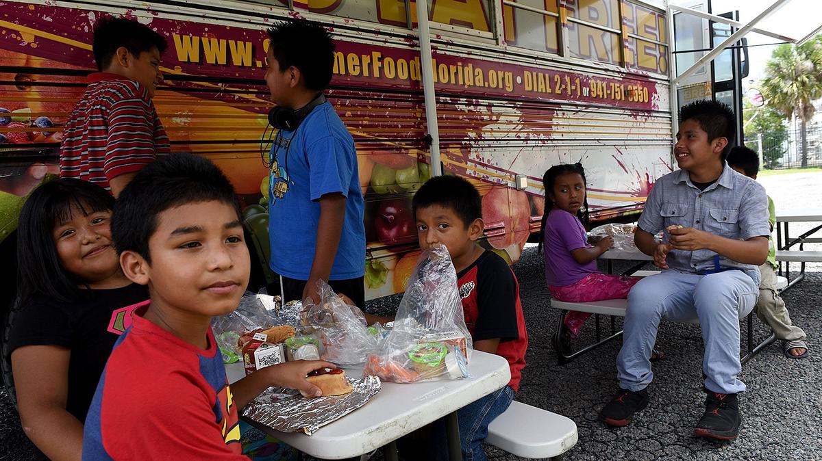 Children eat lunch as part of the Summer BreakSpot program, free lunches, at an East Bradenton park Monday.