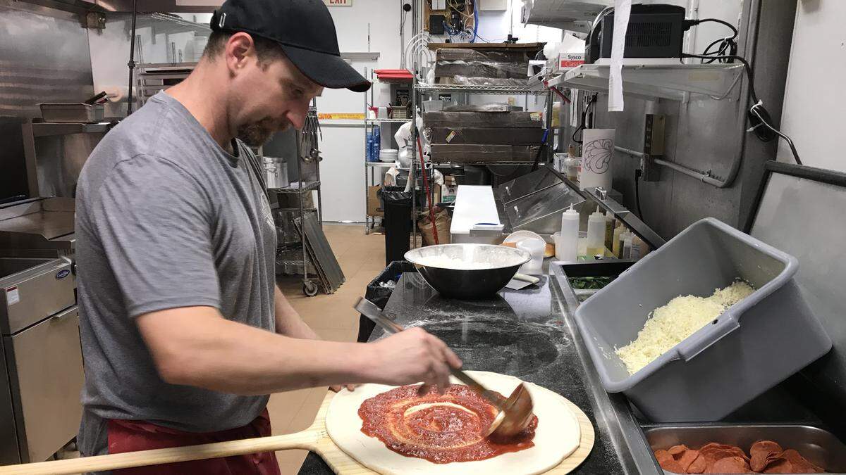 Bill  Nehila ladles on the sauce as he builds a pepperoni pizza at Jersey Brothers Pizza and Pasta. The business specializes in traditional hand-tossed thin crust pizzas.