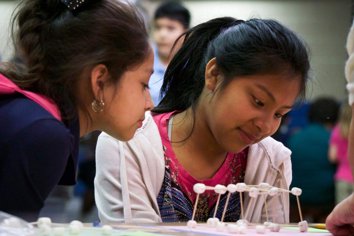 Valeria Arroyo, 9, and Liliana Cortez, 11, build three-dimensional objects out of toothpicks and marshmallows on Thursday evening, when Palm View Elementary School hosted a STEM fair.