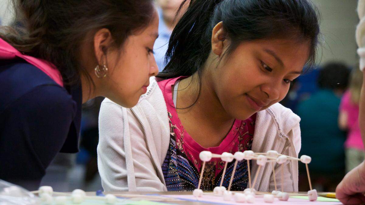 Valeria Arroyo, 9, and Liliana Cortez, 11, build three-dimensional objects out of toothpicks and marshmallows on Thursday evening, when Palm View Elementary School hosted a STEM fair.