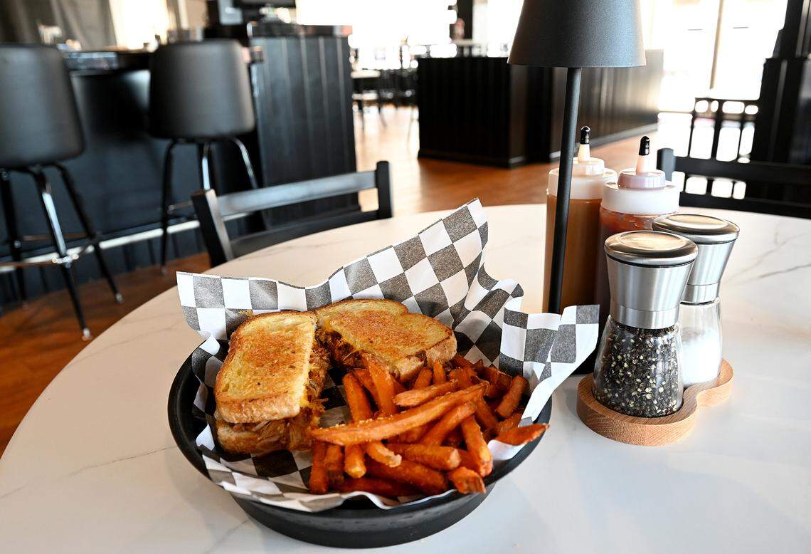 The pork melt sandwich with sweet potato fries at Pork Belly’s, 9516 Cortez Road West.
