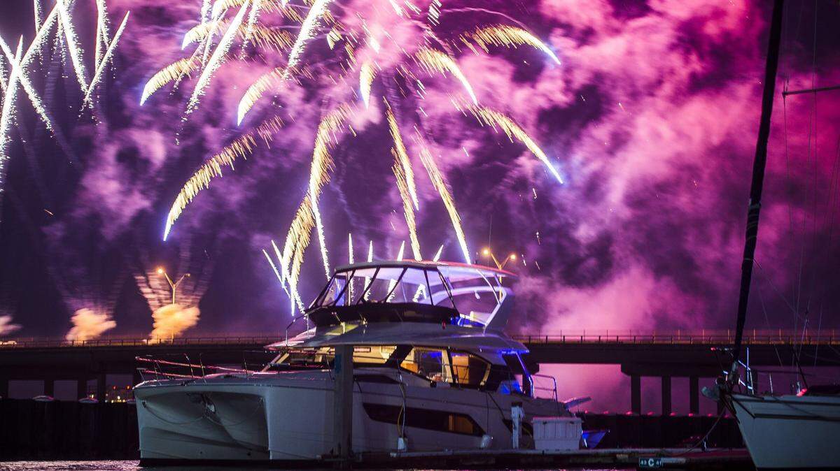 Fireworks explode in the distance behind a boat on the Manatee River in Bradenton.