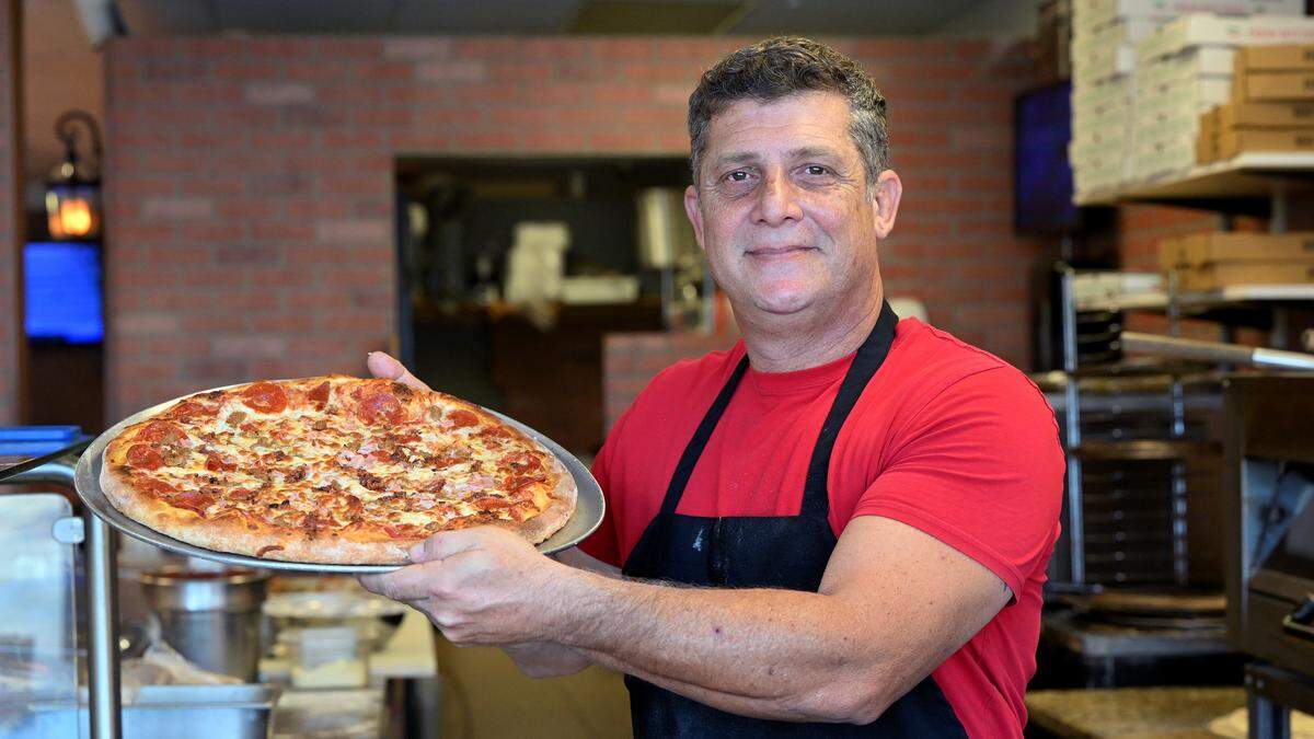 Owner Mark Nilsen poses with a pizza at the new Cornerstone Pizza at 5203 Cortez Road West on Dec. 10, 2025.
