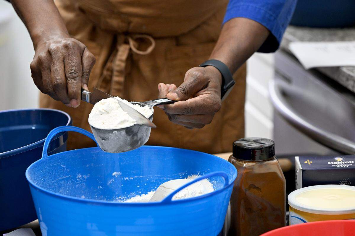 Celebrity chef Marvin Woods demonstrates the proper way to measure flour at Visible Men Academy how to make apple pies for Thanksgiving.