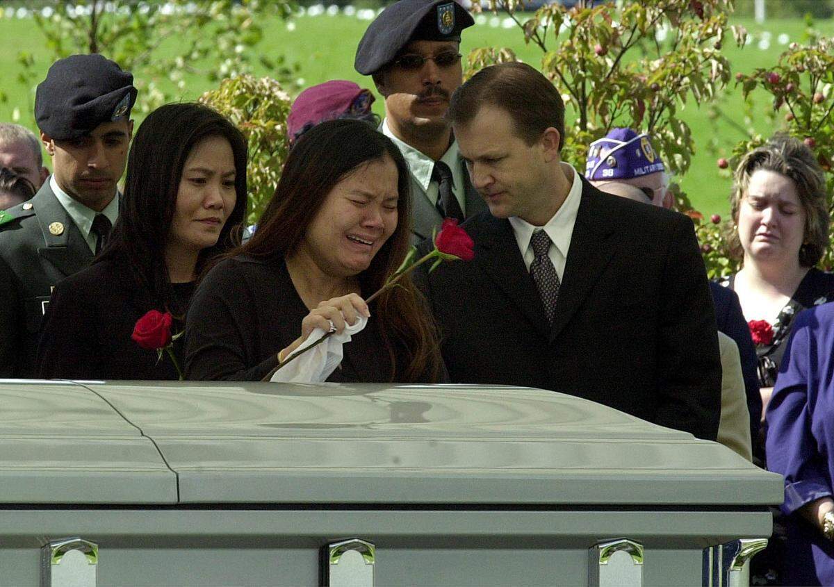 Jamie Miller, the pregnant widow of Staff Sgt. Fred Miller who was killed in Iraq last week, tearfully places a rose on her husband’s casket at the small, rural New Jersey cemetery on Sept. 29, 2003.
