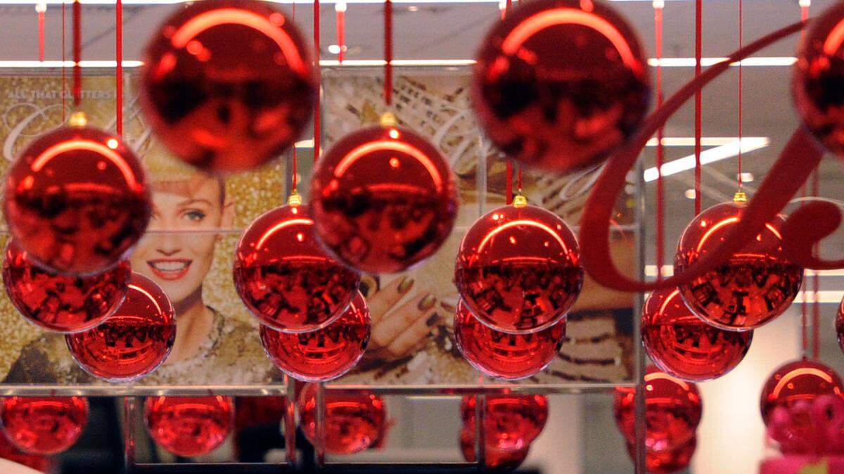 Colorful red ornaments hang from the ceiling at Macy's in The Mall at University Town Center on Black Friday. 
 GRANT JEFFERIES/Bradenton Herald