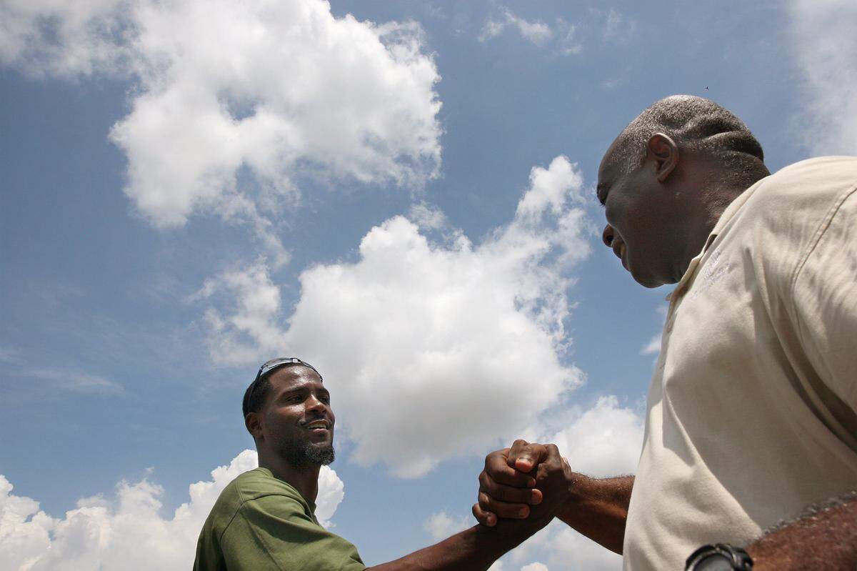 Bayshore grad and Oakland Raider Fabian Washington clasps the hand of Bradenton Boys and Girls Director Willie Cooper. Washington was touring the facility and discussing the Franchise Kids Foundation’s partnership with the club in 2007.