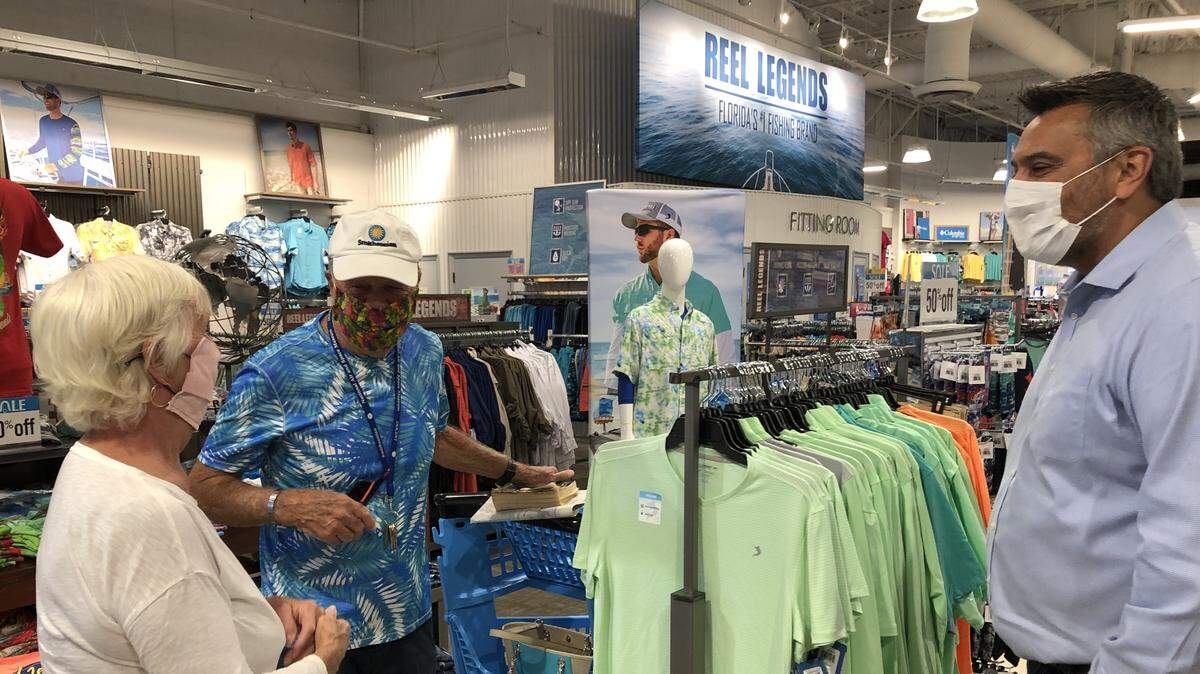Bealls president Dave Alves, right, chats with customers Betty Ebert and Tim McCarthy on Friday at the company’s flagship store at 6837 Manatee Ave. W.