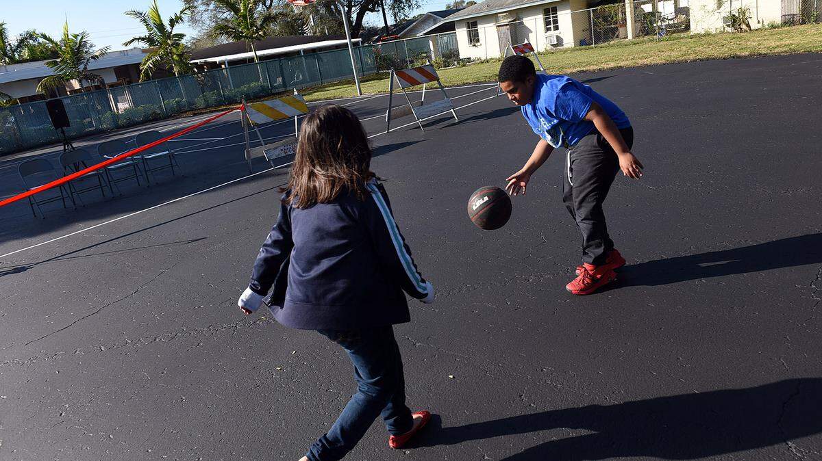 Jayden Chavez, 8, and Camron Johnson, 11, play basketball before the ribbon cutting Wednesday of the basketball court on 16th Avenue and 13th Street West built with a $5,000 donation from the Bradenton Police Department forteiture fund. Chief Michael Radzilowski said in a release: "Our hope is that this court leads to both continued community enhancement and partnership between our citizens and the police department." 
 TIFFANY TOMPKINS/Bradenton Herald