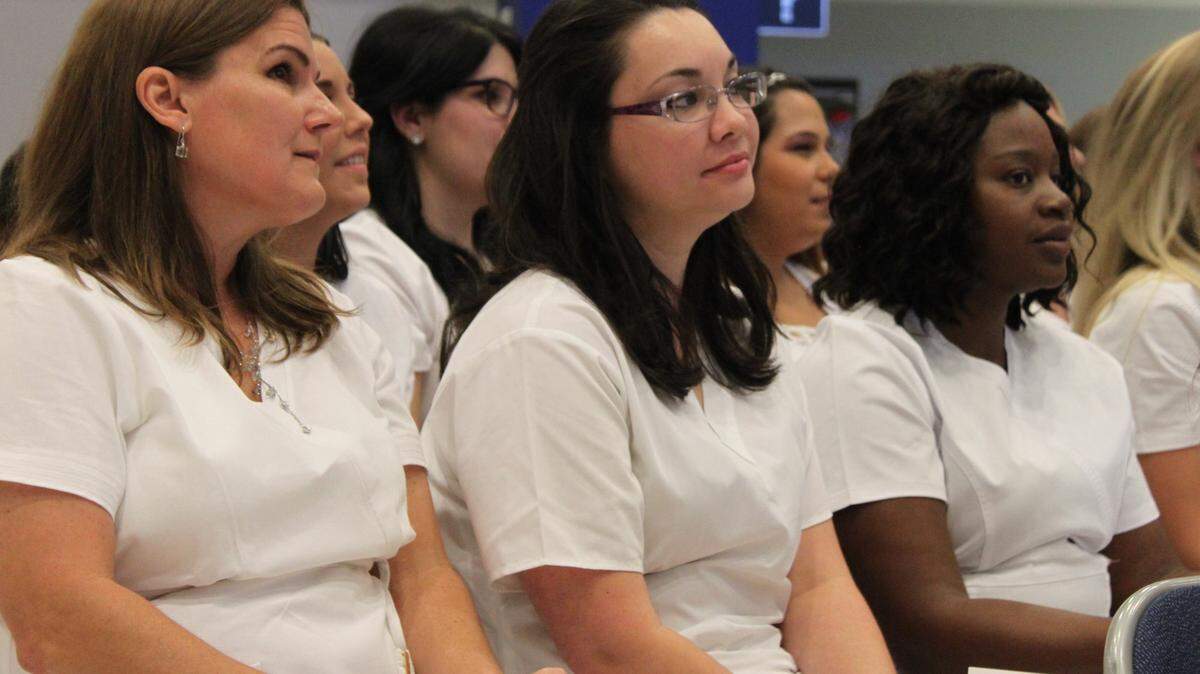 Graduates June Sturdy, Sarah Delke, Bona Hallmon listen to a speaker Thursday night at Manatee Technical College. 
 PHOTO PROVIDED
