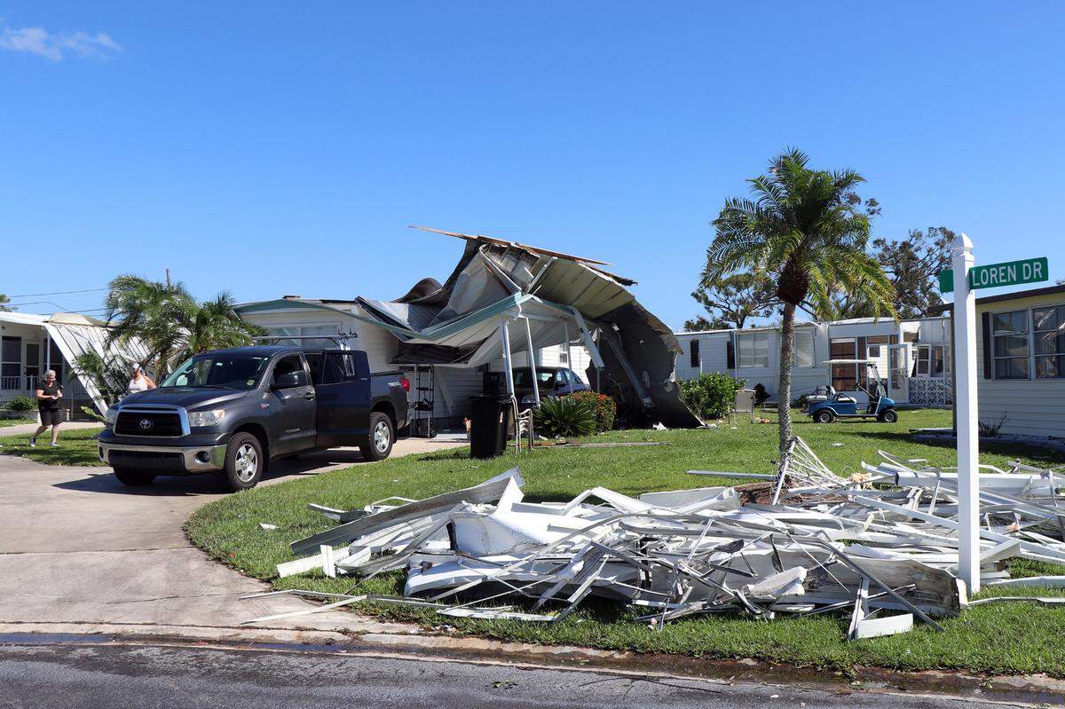 Residents in Orange Acres work on fixing a badly damaged home in Sarasota, Fla., Oct. 12, 2024. The manufactured house had its roof cave in during Hurricane Milton, after the retirement community suffered an earlier blow from Helene. (Kylie Williams/WUFT News)