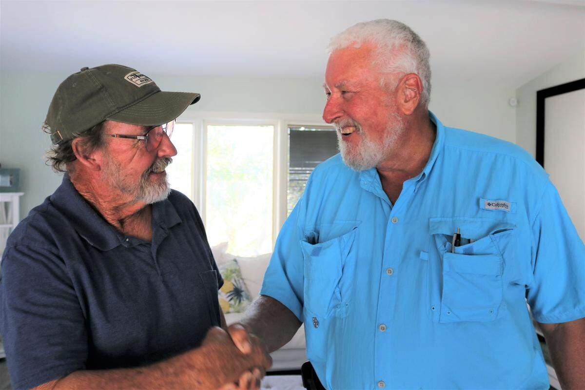 Charter boat captain Scott Moore, left, got the surprise news at home from Ralph Garrison that he had been selected for the Manatee County Agricultural Hall of Fame in recognition of decades of environmental conservation work.