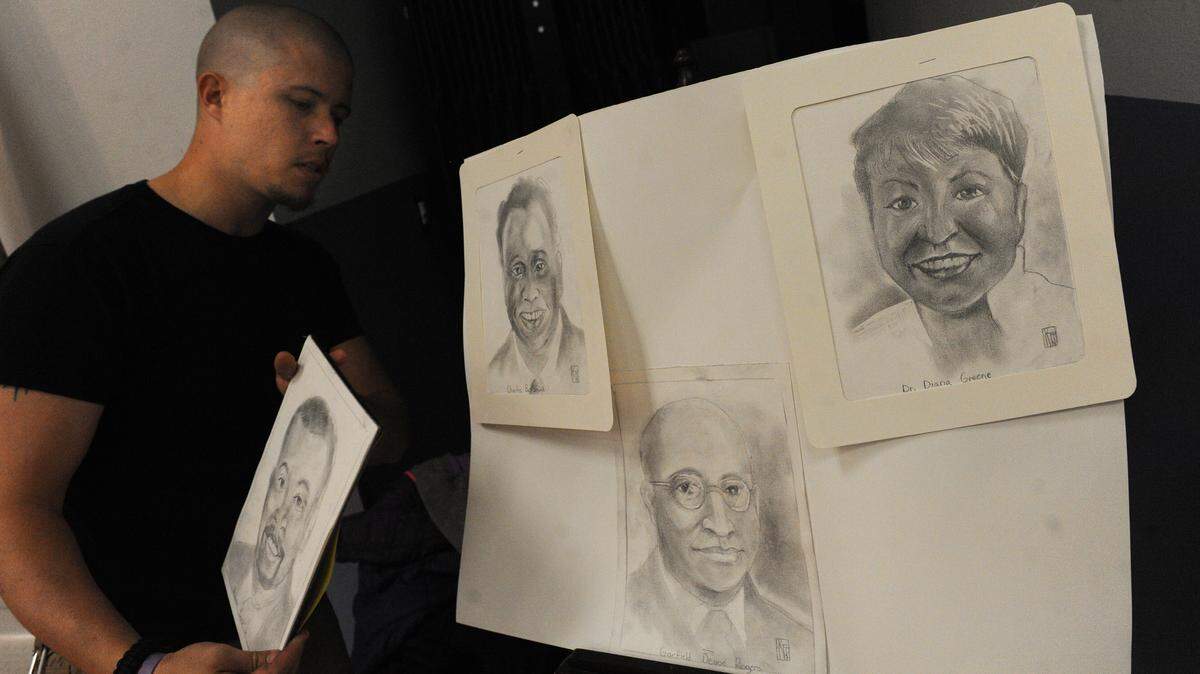 Art teacher Kenny Thompson Jr. displays drawings of local black community leaders during a Black History Month celebration in 2016 at Rogers Garden Elementary. 
 GRANT JEFFERIES/Bradenton Herald