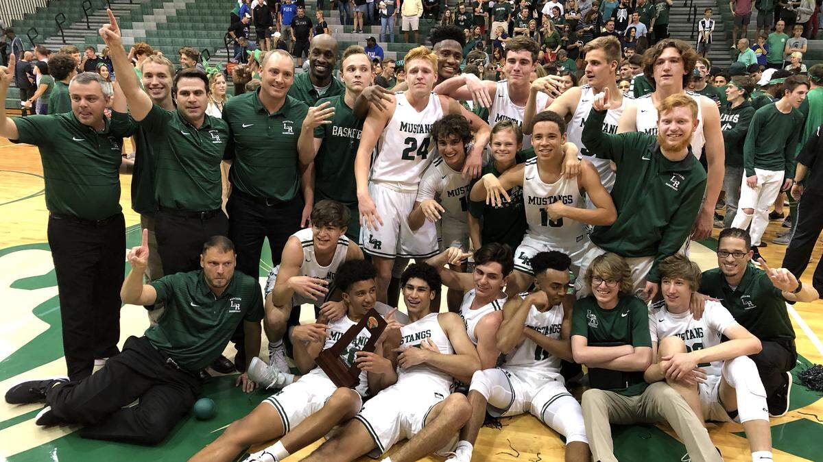 Lakewood Ranch players celebrate with the regional championship trophy after Friday’s 57-47 win against Tarpon Springs East Lake.