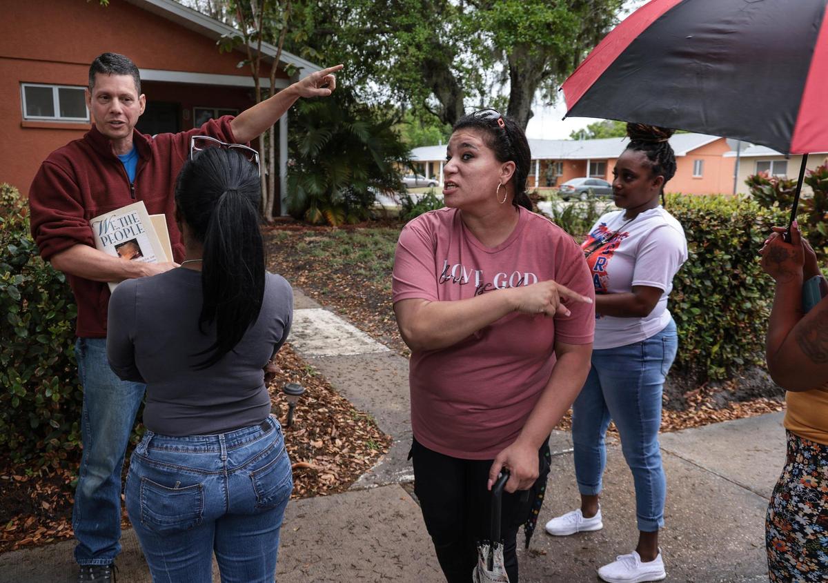 Jason Kraft, a resident commissioner of the Housing Authority Board, avoids answering questions by the group of women lead by public housing advocate Shavonda Griffin, second from the left.