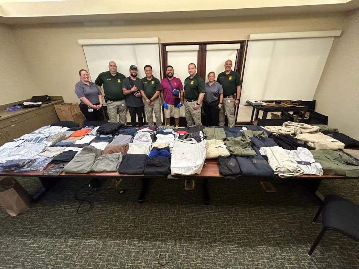 Sarasota County Sheriff’s Office personnel stand behind an evidence table full of Lululemon clothing on May 26, 2023.
