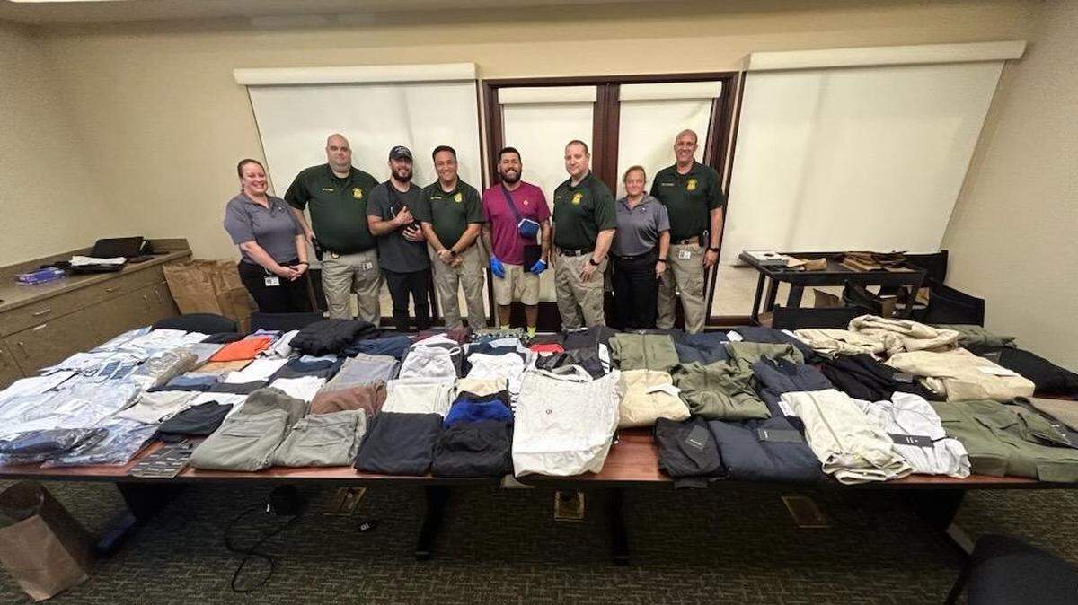 Sarasota County Sheriff’s Office personnel stand behind an evidence table full of Lululemon clothing on May 26, 2023.