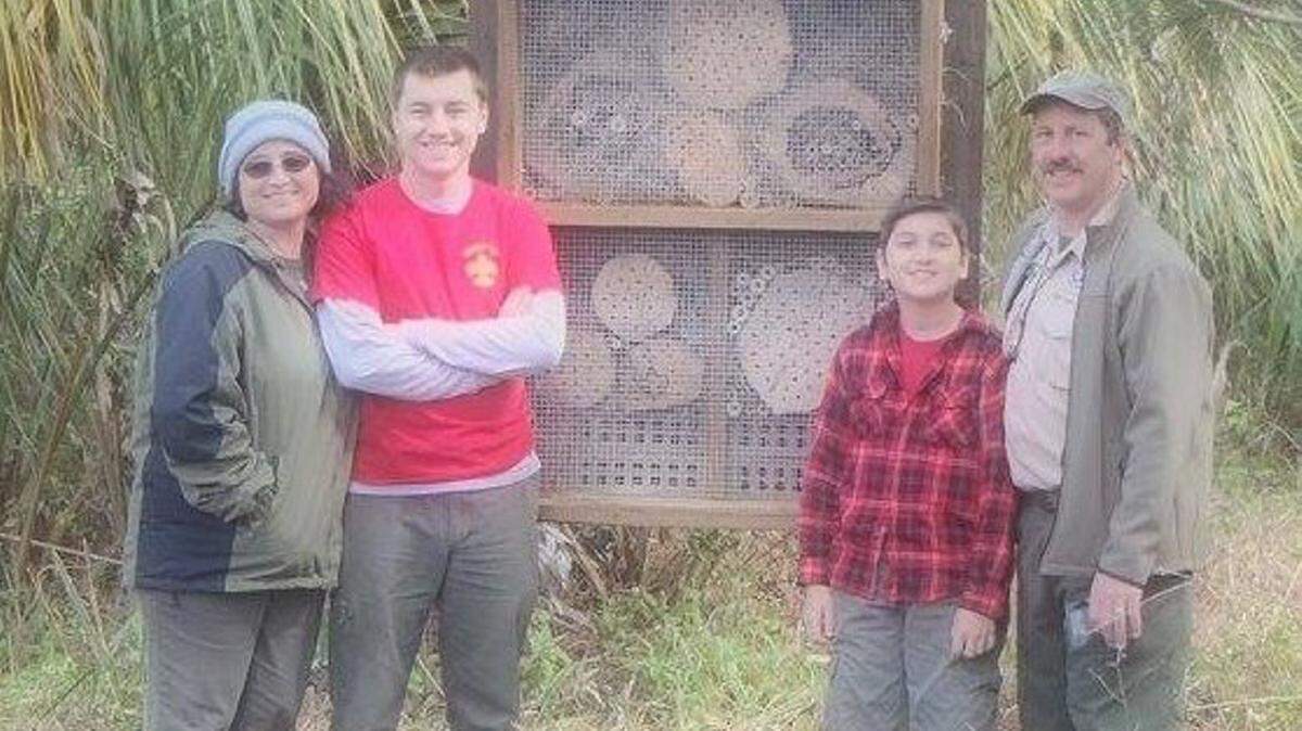From left: Nikki, Dakota, Wyatt and Scott Lupinski at the bee hotel. The bee hotel made of wood and chicken wire is used by solitary bees to meet, nest and repopulate because they don't live in hives. PHOTO PROVIDED