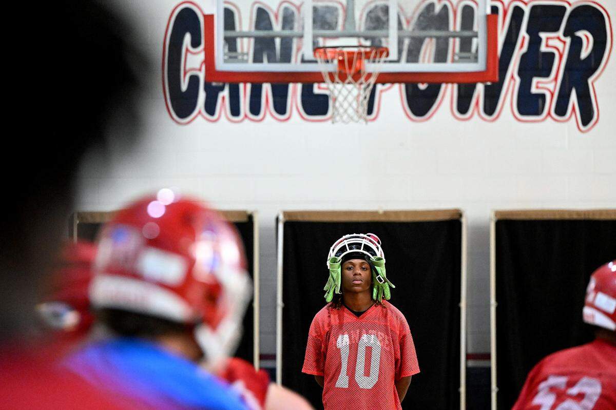 The Manatee Hurricanes High School football team practice indoors in the JROTC gym on the campus as the heat index pushed 94 outside. B.J. Bean, Jr. watches teammates practice.