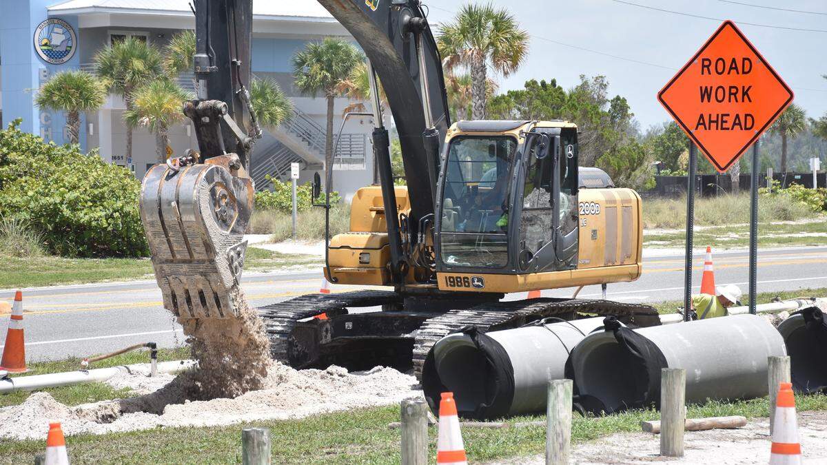 A construction workers uses a crane to dig a hole along Gulf Drive South adjacent to the Coquina Beach parking lot. A stormwater pipe will be installed to improve drainage in the area.