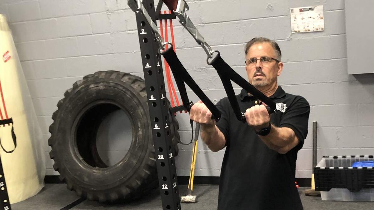 Steve Valley, shown above working on TRX straps, recently opened Manatee Fit Body Boot Camp, 5917 Manatee Ave. W, Suite 107, and is following protocols to keep members safe from COVID-19.