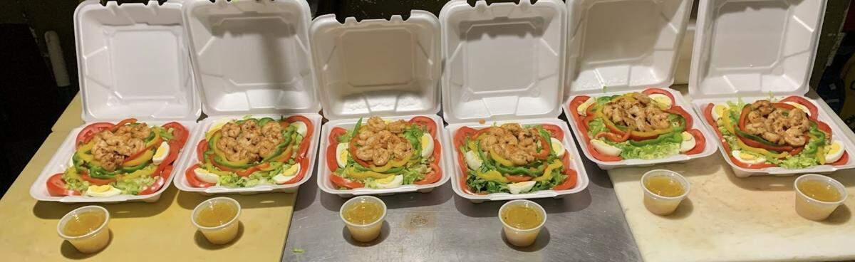 Rodney’s Jamaican Grill shrimp salads are lined up and ready to go for hungry customers.
