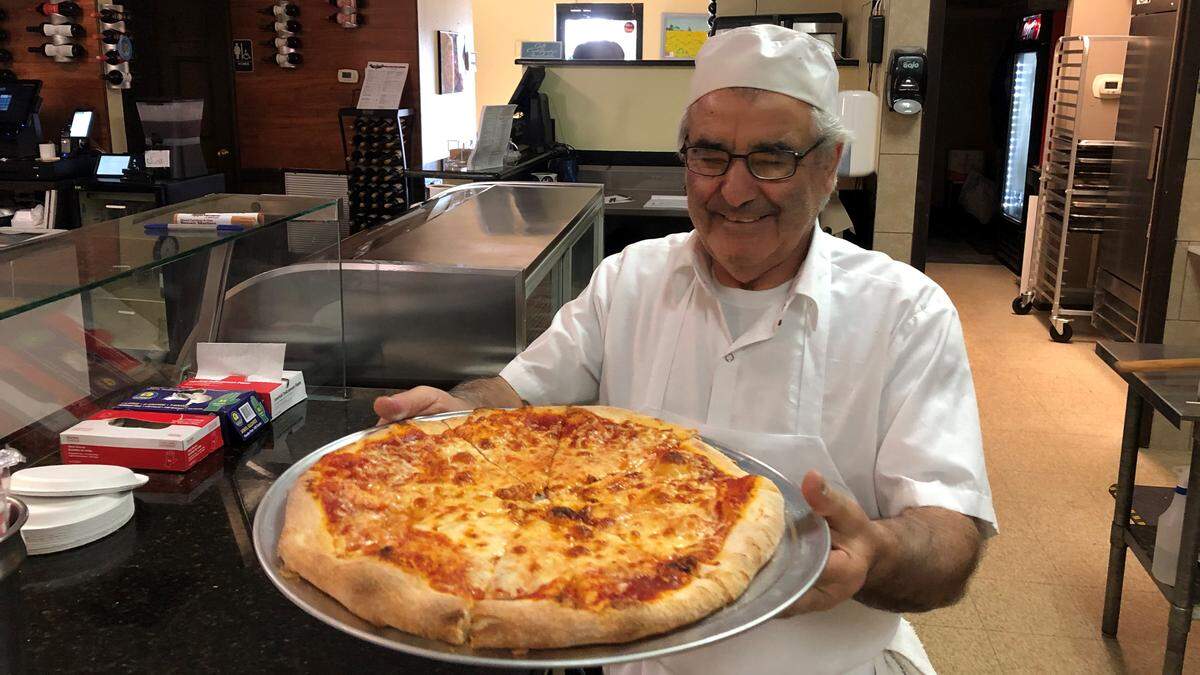 Joe Scarpino presents a hot-out-of-the-oven cheese pizza at Rocco’s Pizza and Pasta Grill, 827 14th St. W., Bradenton.